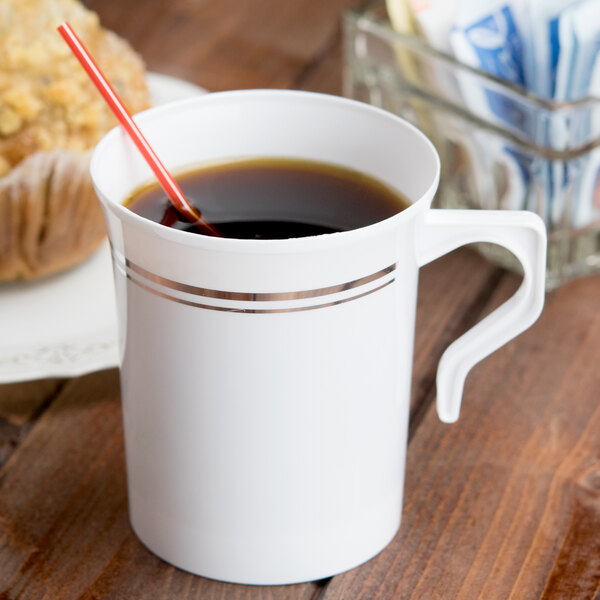 A white Visions plastic coffee mug with a straw in it.