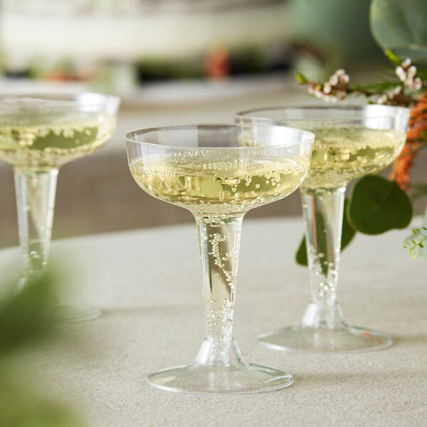 Three Visions clear plastic champagne glasses on a table.