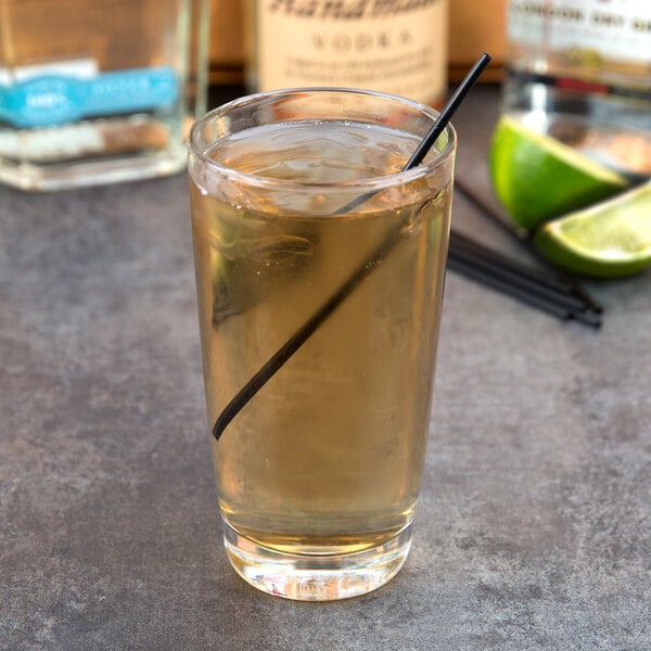 A Libbey highball glass filled with liquid and a straw.