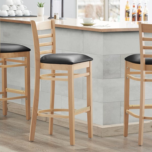 Lancaster Table & Seating Natural Ladder Back Bar Height Chair with Black Padded Seat - Preassembled