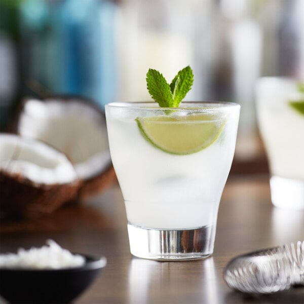 A glass of coconut lime drink with a lime wedge.