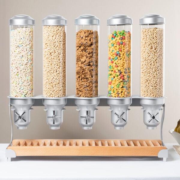 A Cal-Mil beechwood cereal dispenser on a hotel buffet shelf filled with cereals.