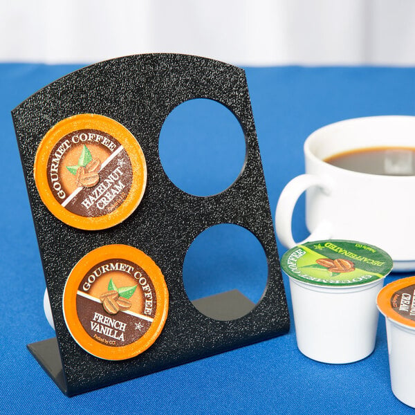 A black Cal-Mil coffee pod holder with white cups of coffee on it.