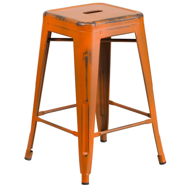 A Flash Furniture distressed orange metal counter height stool with a drain hole seat.