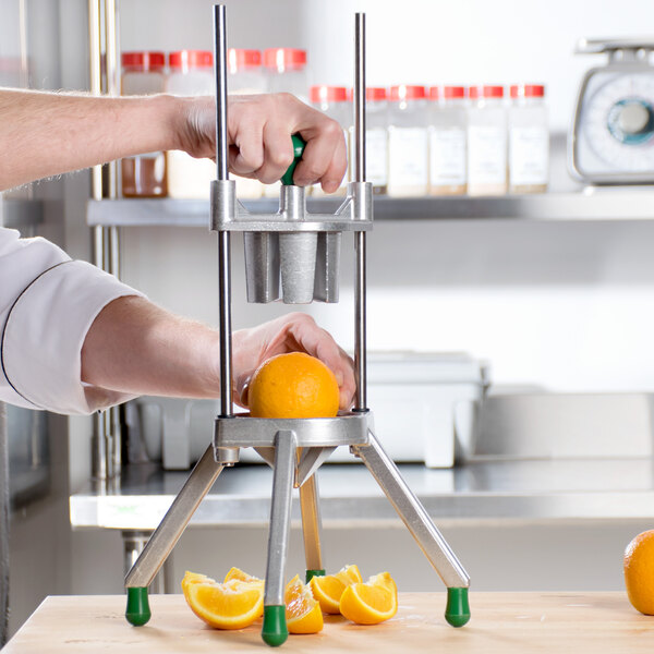 A person uses the Garde 6 Section Fruit Wedge Cutter to cut an orange into wedges.