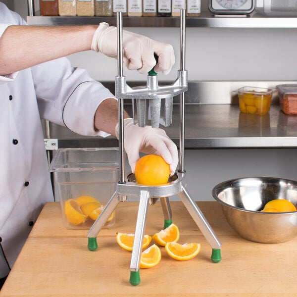 A man using a Garde fruit wedge cutter to cut oranges.