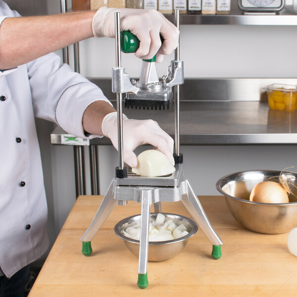 A chef using a Garde Heavy-Duty Vegetable Dicer to chop onions into a metal bowl.