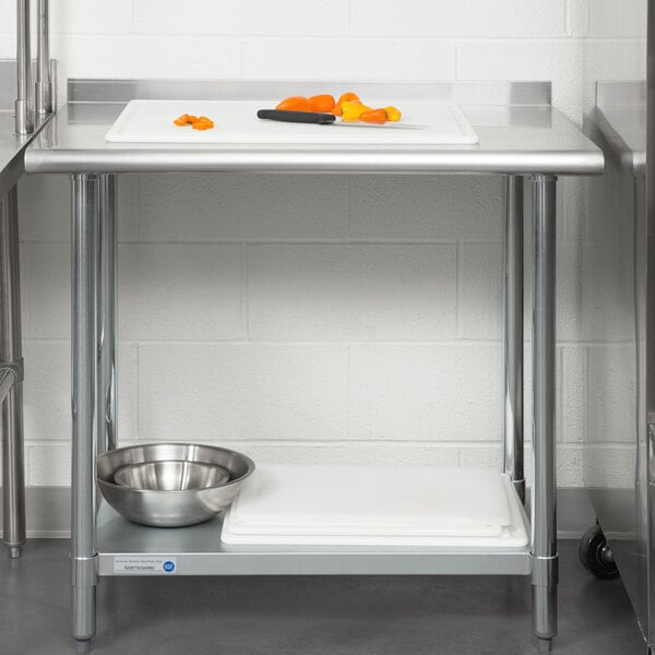 A Steelton stainless steel work table with undershelf and rear upturn with a cutting board, knife, and bowl.