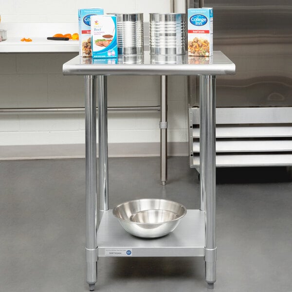 A silver metal Steelton work table with a metal shelf holding a metal bowl.