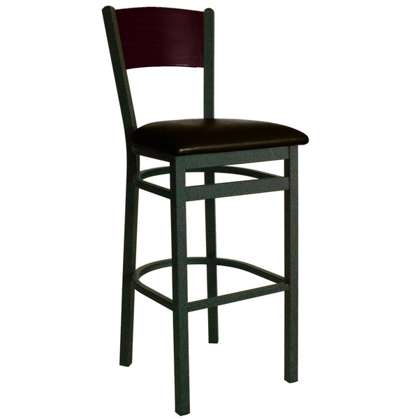 A BFM Seating black metal bar stool with mahogany wood back and dark brown vinyl seat.