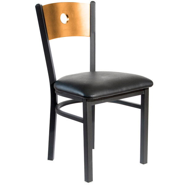 A BFM Seating black metal side chair with a natural wooden back and black vinyl seat.