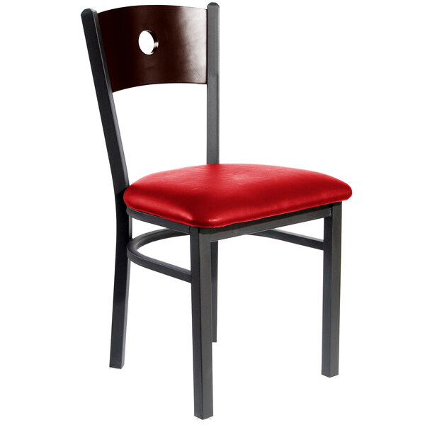 A BFM Seating metal side chair with a walnut wooden back and red vinyl cushion.