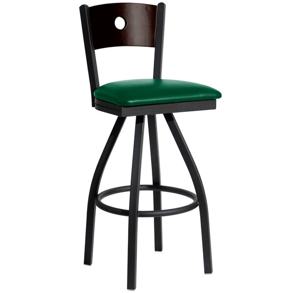 A BFM Seating black metal restaurant bar stool with a green vinyl swivel seat.