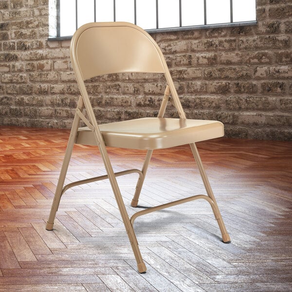 A beige National Public Seating metal folding chair.