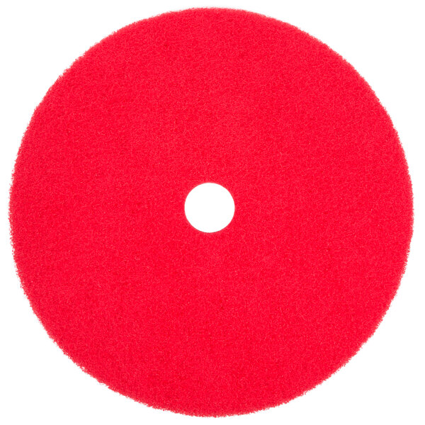 A red circular Scrubble floor pad with a hole in the center.