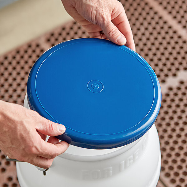 A person holding a blue Choice 5 Gallon Ice Tote Lid.