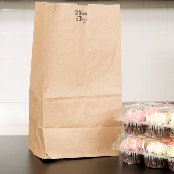 A Duro brown paper bag with a white handle filled with cupcakes.