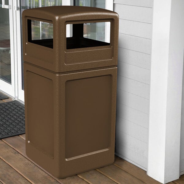 A brown Commercial Zone PolyTec waste container with dome lid on a porch.