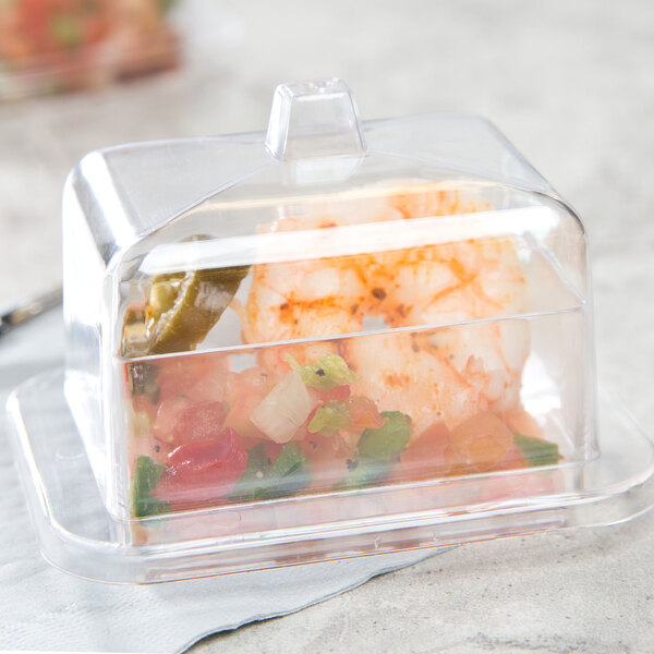 A clear plastic rectangular tray with a shrimp cocktail in it.