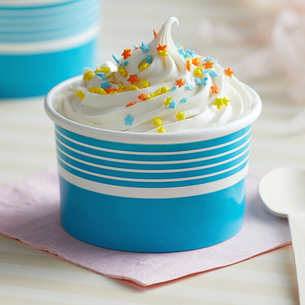 A blue paper cup filled with ice cream and sprinkles.