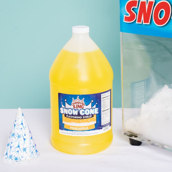 A close up of a Carnival King Pineapple Snow Cone Syrup bottle filled with yellow liquid.