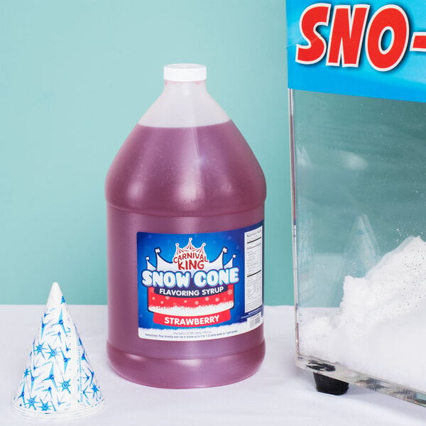 A bottle of Carnival King strawberry snow cone syrup next to a snow cone.