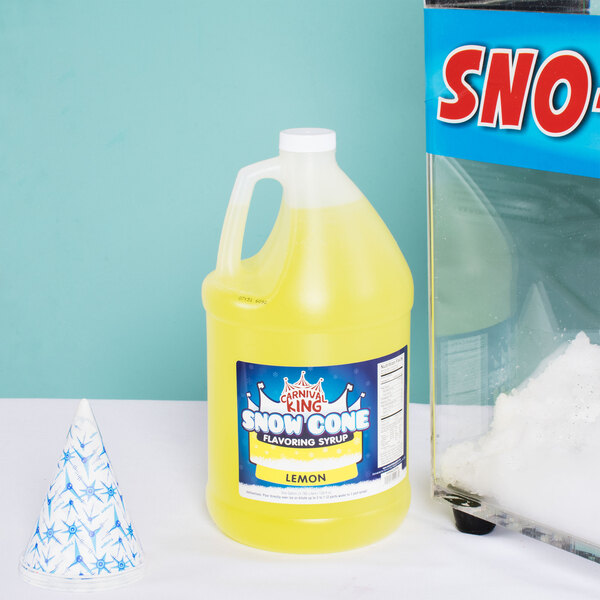 A jug of Carnival King lemon snow cone syrup next to a snow cone.