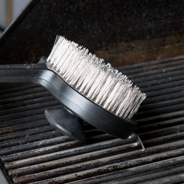 A Chef Master grill cleaning brush with dual handle brushes a grill.