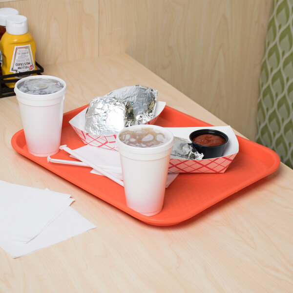 A customizable orange plastic fast food tray with food on it on a table.