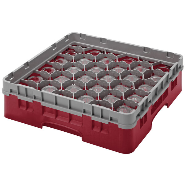 A red and grey plastic Cambro glass rack with round glass inside.
