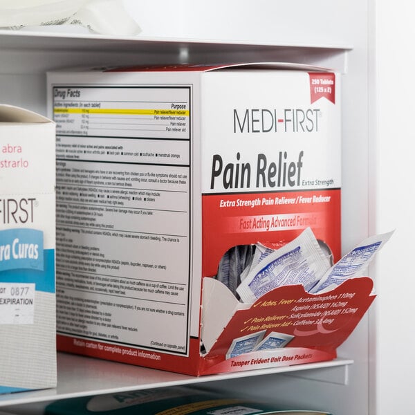 A Medi-First box of pain relief tablets with a blue label on a shelf.