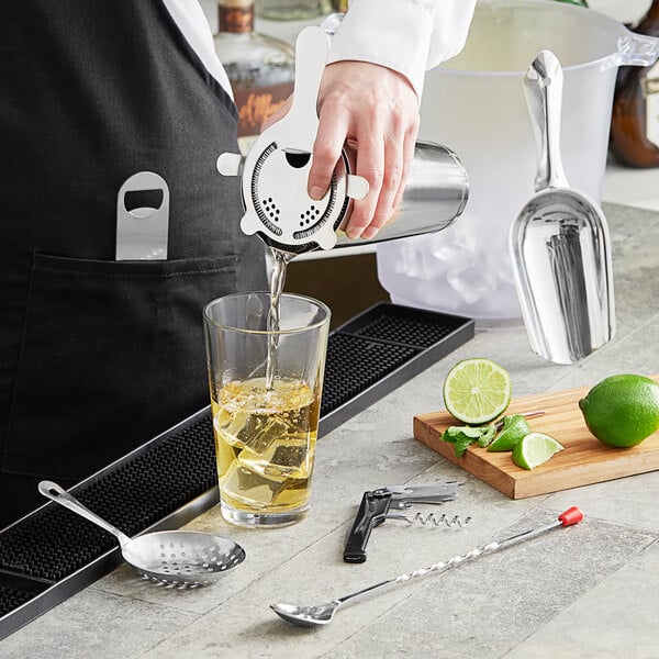 A person using the Choice 8-Piece Starter Cocktail Kit to pour a cocktail.