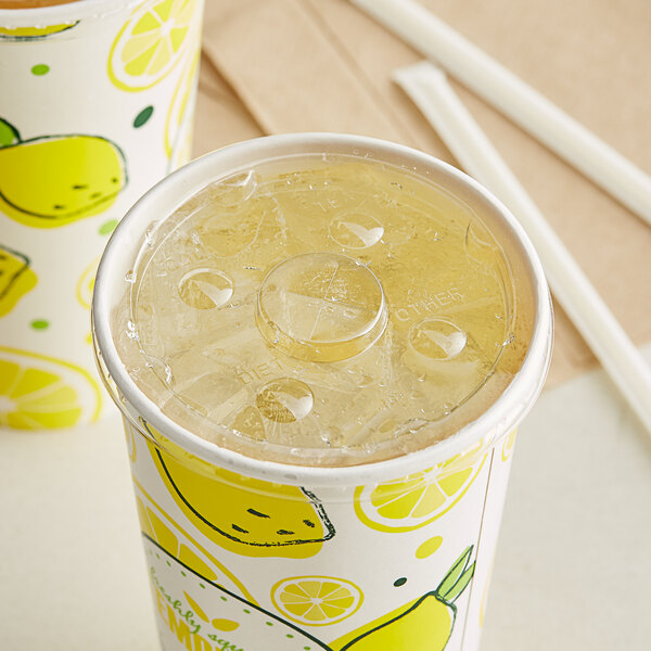 A Choice translucent cold cup lid with a straw slot over a cup with a lemon design on it.