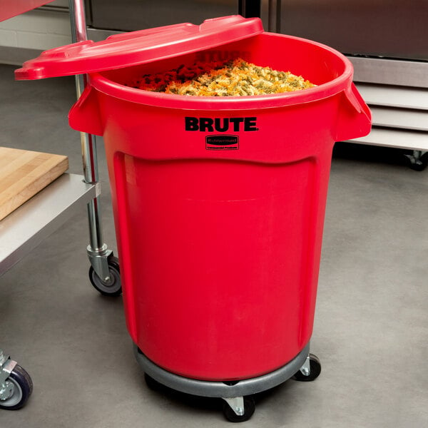 A red Rubbermaid BRUTE trash can with lid and dolly with food inside it.