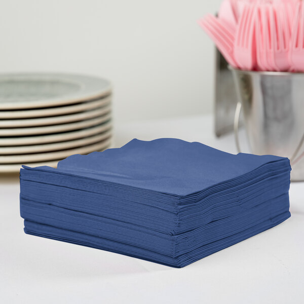 A stack of navy blue Creative Converting luncheon napkins.