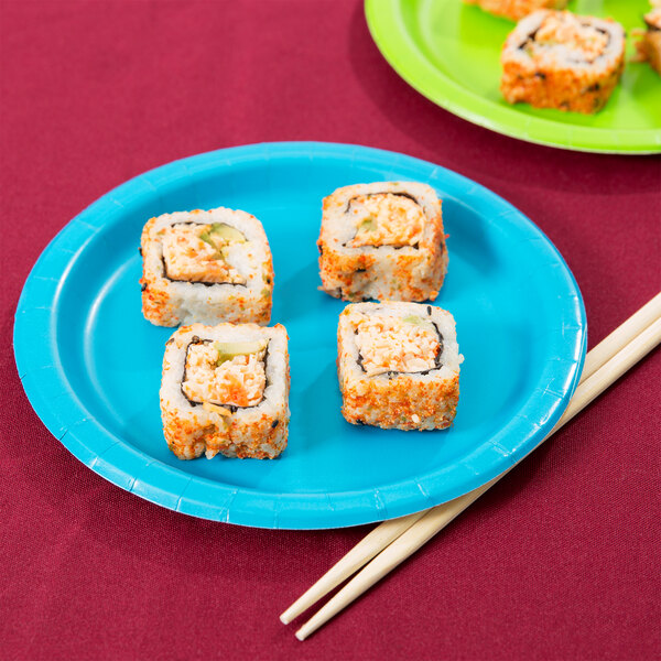 A turquoise blue paper plate with sushi and chopsticks on it.