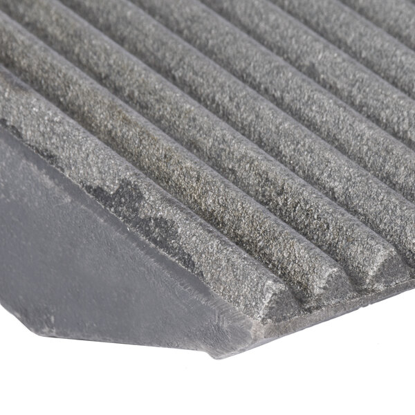 A close-up of a grey metal surface with grooves.