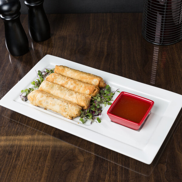 A Libbey porcelain tray with fried spring rolls and dipping sauce.