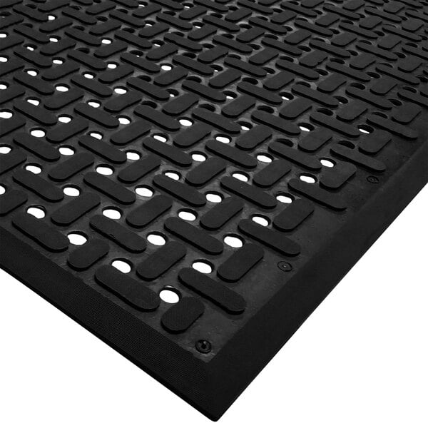 A close up of a black Cactus Mat anti-fatigue floor mat with holes in it.