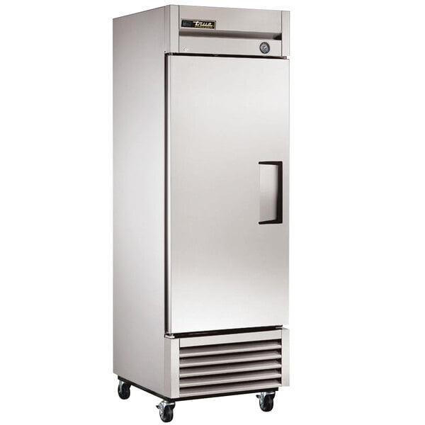 A close-up of a large silver True reach-in refrigerator with a left-hinged door.