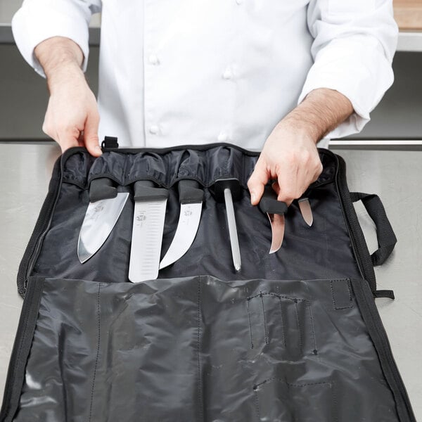 A chef holding a Victorinox knife set in a black case.
