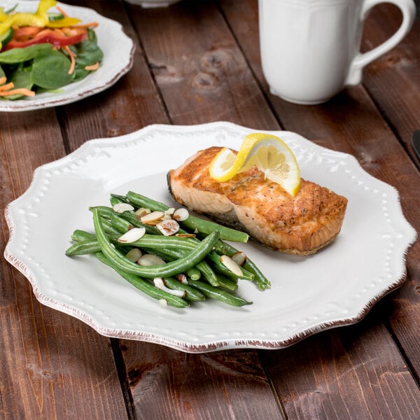A 10 Strawberry Street Oxford brown rim stoneware plate with fish, green beans, and lemon wedges.