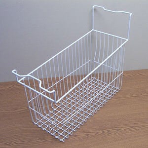 A white wire basket for an Excellence Commercial Ice Cream Freezer on a wood surface.