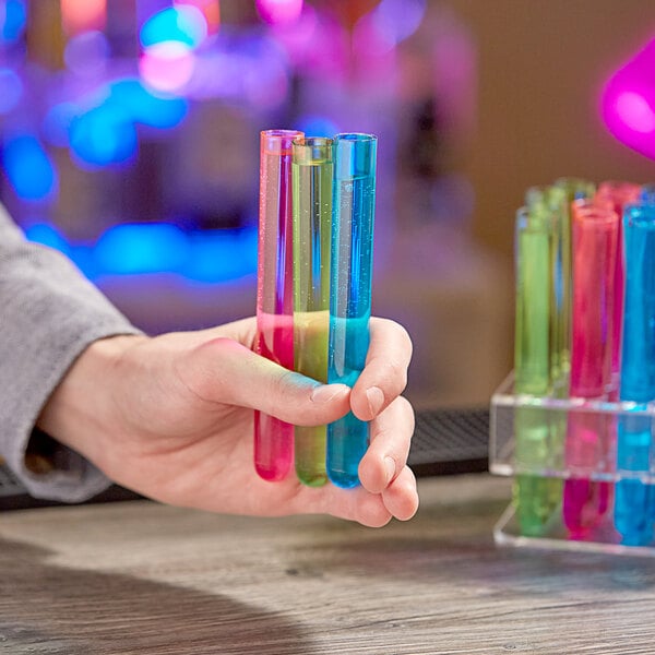 A hand holding Choice neon plastic test tubes filled with colorful liquid.