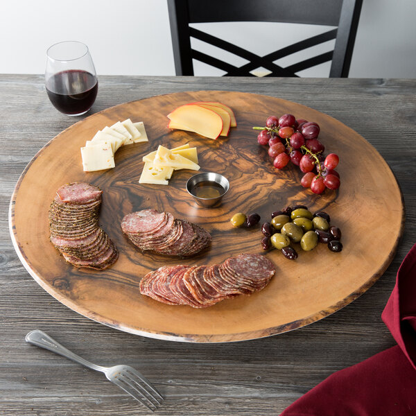 An American Metalcraft faux olive wood melamine serving board with meat, cheese, and grapes on a table.