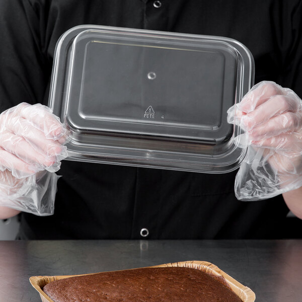 A person holding a clear plastic container with a Solut brownie pan inside.