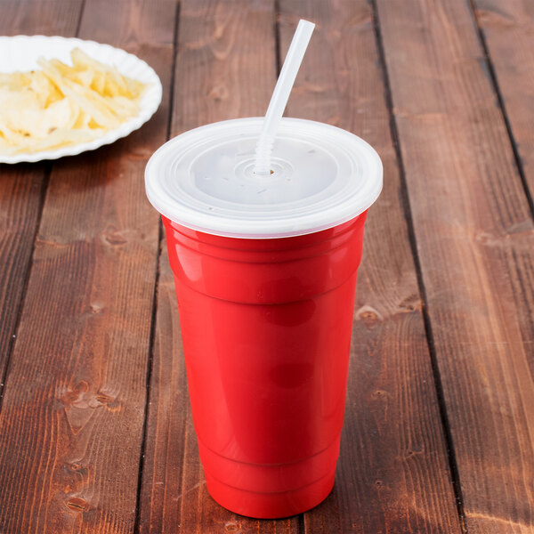A red GET tumbler with a white lid and straw on a table with a plate of chips.