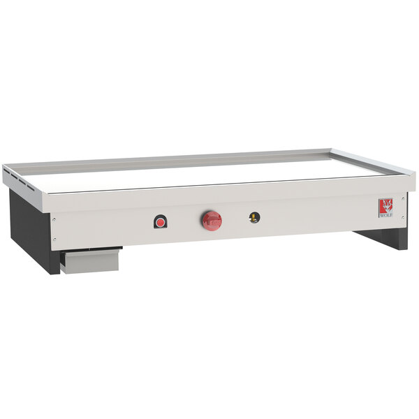 A white rectangular Wolf Teppanyaki gas countertop griddle with red knobs.