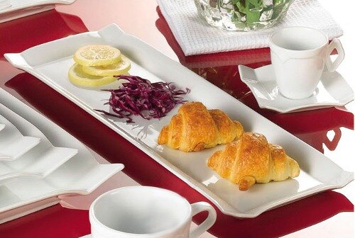 A CAC Times Square rectangular white china platter with food on a table.