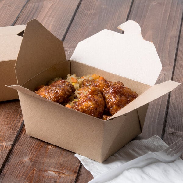 A Kraft paper Fold-Pak Bio-Plus Earth take-out box with chicken and rice inside.